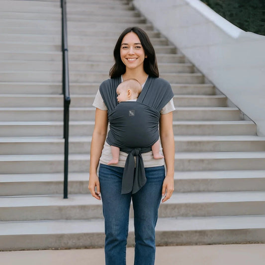 Une femme portant son bébé dans une Écharpe de portage Mymombox, gris ardoise