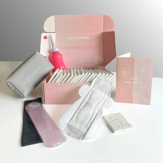 Box Post-Partum MyMomBox ouverte dévoilant ses accessoires : carnet Post-Partum, trousse, bidet portable,  20 serviettes hygiéniques et une bande chaud-froid pour soulager les douleurs.